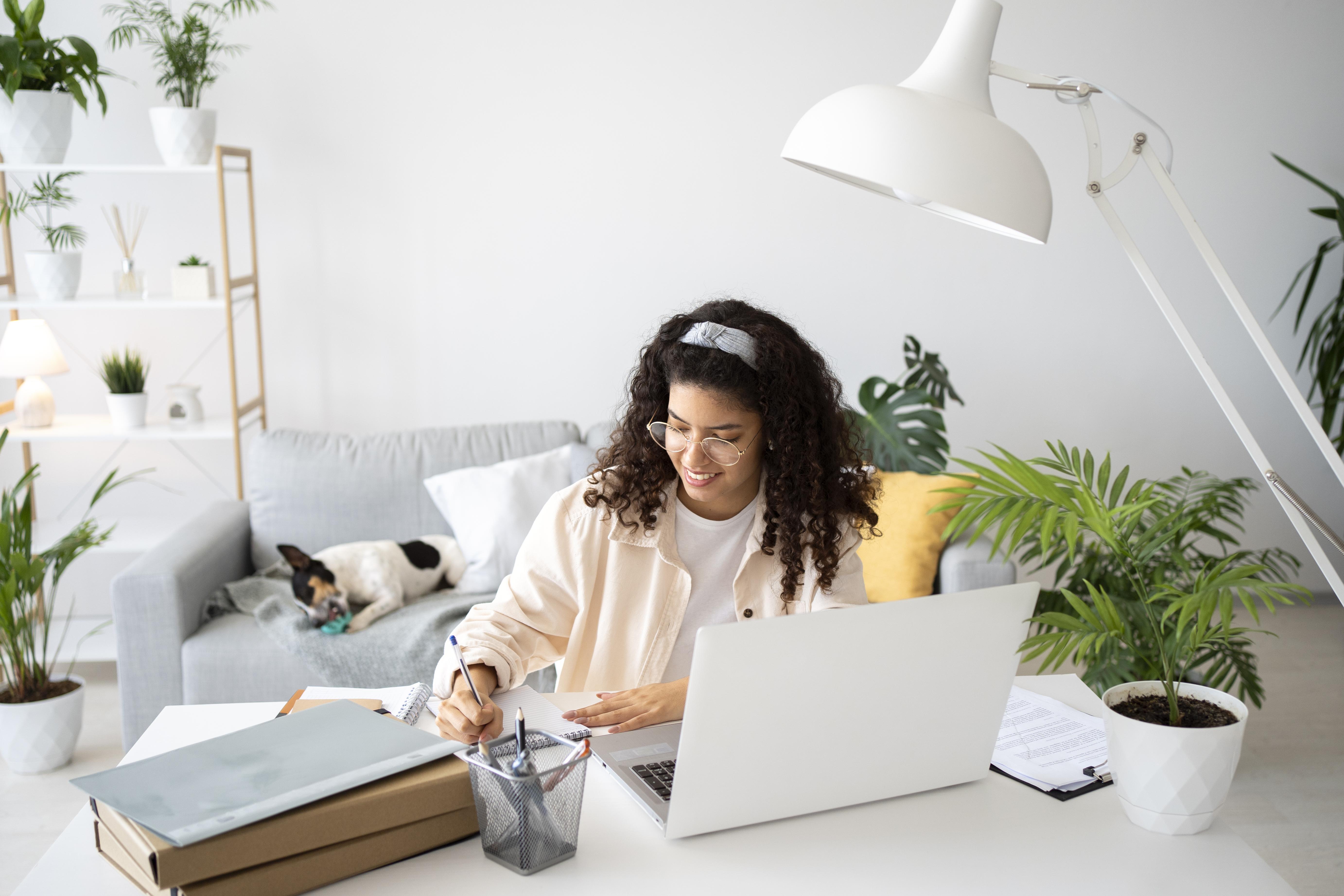 Deciding between rent or buy: medium-shot-woman-working-desk-with-laptop